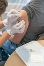 Vertical view of a female doctor disinfecting a female patient`s arm after a vaccination