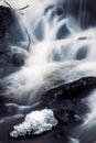 Vertical view of the foamy waves of a river flowing down the rocks in daylight in a forest Royalty Free Stock Photo