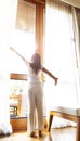 Vertical view with Fresh of young woman open a curtains and stretching in bed after waking up, sunlight in morning and open the Royalty Free Stock Photo