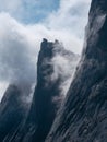 Vertical view of great mountains in the fog. Low clouds and dark peaks of the mountains. Atmospheric surreal landscape with dark Royalty Free Stock Photo