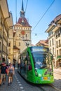 Vertical view of green tram and KÃÂ¤figturm or prison tower in Marktgasse street in Bern old town Switzerland