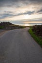 Vertical view of lonely local road with sunset on the sea Royalty Free Stock Photo