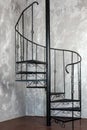 Vertical view of a metal dark spiral staircase in loft interior.