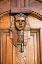 Vertical View of an Old Clapper With Egyptian Faces on a Decorated Wooden Old Door Royalty Free Stock Photo