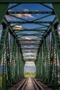 Vertical view through old, iron, railway bridge during sunset Royalty Free Stock Photo