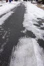 Vertical view of a partially cleared snow and ice covered asphalt street