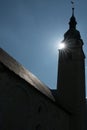 Vertical view of the Protestant church in the village of Spluegen in the Swiss Alps in silhouette with the sun shining bright