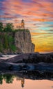 Vertical view of Split Rock lighthouse at the edge of the cliff reflecting in the water at sunset Royalty Free Stock Photo