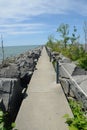 Vertical view of a stone pathway leading to the endless ocean under the blue sky