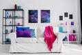 Vertical view of stylish living room with comfortable white couch with pink blanket and blue and purple pillows, cosmos graphics o Royalty Free Stock Photo