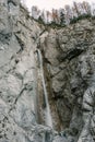 Vertical view of a waterfall tumbling down a cliff with trees above in Slovenia Royalty Free Stock Photo