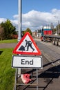 Vertical view of well used End of Roadwork temporary sign by the side of a road Royalty Free Stock Photo