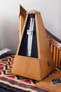 Vertical view of a wooden metronome over the tablecloth Royalty Free Stock Photo