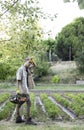 Vertical view of young hipster man tired working hard in the garden collecting vegetables in a basket Royalty Free Stock Photo