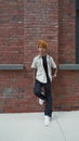 Vertical view of the young mixed race man with relaxed expression standing at the street.