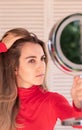 Vertical view of young woman suffering from alopecia. Female hair loss.Worried female looking her hairline in the mirror Royalty Free Stock Photo