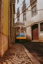 Vertical of a vintage tram in a narrow street in Lisbon, Portugal