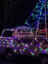 Vertical of a vintage Volkswagen pickup decorated with colorful and vivid Christmas lights