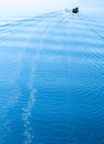 Vertical vivid boat in ocean with water trace