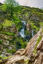 Vertical of a waterfall cascades down the rocky mountainside in Scotland Royalty Free Stock Photo