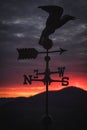 Vertical of weather vane with an eagle on the top against a fiery sunset Royalty Free Stock Photo