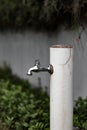 Vertical of a weathered metallic outdoor water tap faucet in the street