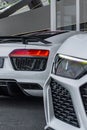 Vertical of a white Audi R8 duo front and rear view outdoors building background