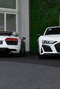 Vertical of a white Audi R8 duo front and rear view outdoors house background