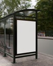 A vertical white blank billboard mockup at a bus stop on a city street. Bus stop poster mockup Royalty Free Stock Photo