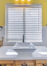 Vertical White ceramic vessel sink with antique faucet fixture against the window with blinds Royalty Free Stock Photo
