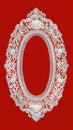 A vertical white lace oval doily frame, top view, on a red background. The lace is embroidered with symmetrical openwork and an Royalty Free Stock Photo