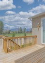 Vertical White puffy clouds Wooden deck of a fenced house with sliding glass door