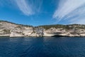 Vertical white rocks with vegetation against the sea and sky with clouds Royalty Free Stock Photo