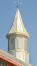 Vertical White tower and weather vane at the roof of a barn at a vinyard against blue sky Royalty Free Stock Photo