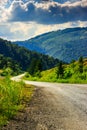 Vertical winding road goes to mountains under a cloudy sky Royalty Free Stock Photo