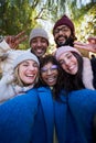 Vertical. Winter time smiling selfie of a happy group of multicultural friends looking at the camera Royalty Free Stock Photo
