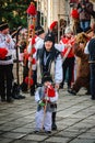 Vertical of a woman and a child dressed in traditional Romanian clothes during the New Year's parade