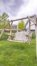 Vertical Wooden bench swing at the lush grassy yard of a home with white picket fence Royalty Free Stock Photo