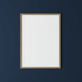 Vertical wooden frame on dark blue wall, poster frame mock up Royalty Free Stock Photo