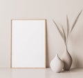 Vertical wooden frame mock up. Wooden frame poster, and simple vase with pampas on beige wall Royalty Free Stock Photo