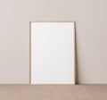 Vertical wooden frame mock up. Wooden frame poster on beige floor with beige wall background. Royalty Free Stock Photo