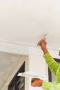 Vertical worker applying plaster with a putty knife on a ceiling surface. Royalty Free Stock Photo