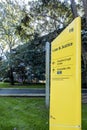 Vertical yellow direction sign to the Law and Justice Building F8 at UNSW