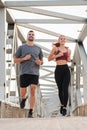 Vertical. Young couple running for health, wellness or training for a marathon, competition or race, showing effort and