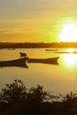 Vertically exposed golden silhouette of two fishing boats at dawn.