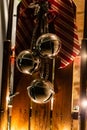 A vertically oriented shot of 3 giant jingle bells hanging on an antique wooden sleigh with a red and white ribbon ready for the Royalty Free Stock Photo