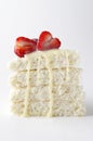 Verticl image.Piece of biscuit cake with slices of strawberry and condensed milk on the white background Royalty Free Stock Photo