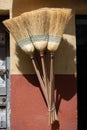 Verticl shot of a set of brooms hanging on the wall under the sunlight Royalty Free Stock Photo