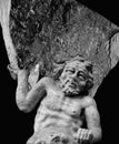 Very ancient stone statue of Sisyphus with stone. God Zeus punished Sisyphus: he had to roll very big stone to top of high