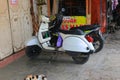 A very antique white Vespa motorbike